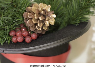 Red Berries With Pine Cones Placed On A Black Velvet Hat.