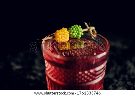 red berry cocktail in a beautiful glass on a dark background