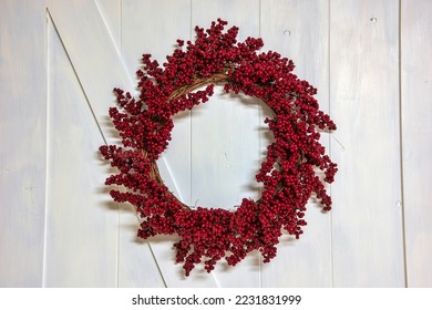 Red berry grapevine holiday wreath on a white barn door - Powered by Shutterstock