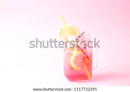 Red berry lavander lemonade, lemon and straw. Virgin strawberry mojito, non alcoholic cocktail with ice in vintage mason jar glass, Isolated on pale pink background. Copy space, top view, close up.