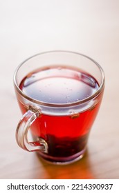 Red Berry Tea In A Transparent Cup On The Background Of A Wooden Table In A Cafe