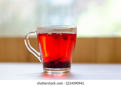 Red Berry Tea In A Transparent Cup On The Background Of A Wooden Table In A Cafe