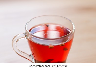 Red Berry Tea In A Transparent Cup On The Background Of A Wooden Table In A Cafe