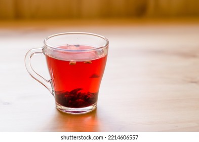 Red Berry Tea In A Transparent Cup On The Background Of A Wooden Table In A Cafe