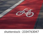 Red bicycle path on which a bicycle passes close-up 
