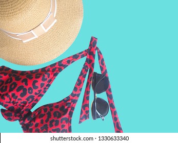 Red Bikini And Glasses With Hat Isolatd On Blue Background. For Summer Travel Holidays At Sea Or 
Swimming Pool. Accessory For 
Tourist Woman.