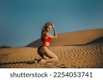 Red Bikini Woman Kneeling on Sand Dunes