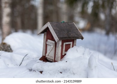 A Red Bird House In The Snow