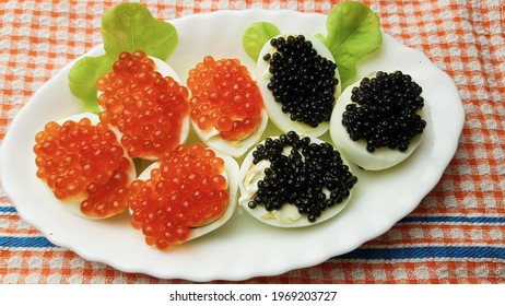 Red And Black Caviar Of Sturgeon Fish On Boiled Eggs. Appetizer For The Festive Table