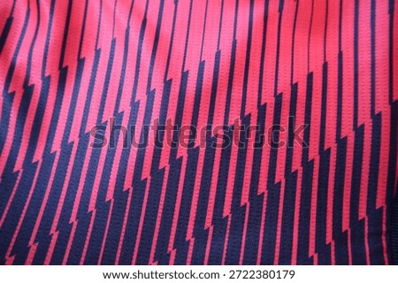 Red and black printed geometric pattern of stripes and zig zags. Shape pattern of bright red and black on a diagonal with a pin stripe effect broken up by the diagonal lines. 