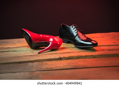 Red and black stylish shoes on the wood floor at night with red light