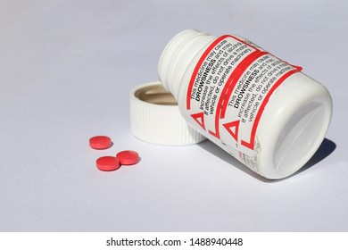 Red, Black And White Medicine May Cause Drowsiness Warning Label On Pill Bottle And Red Pills