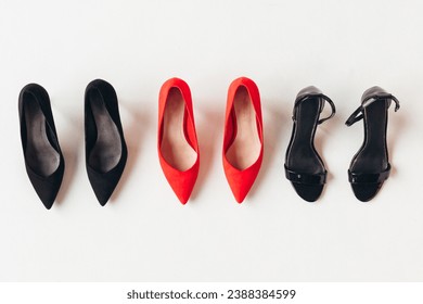 Red and black women's shoes with high heels on white background. Female classic stiletto heels in suede leather. Top view