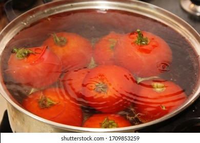 Red blanched tomatoes in a hot water metal pot. tomatoes boil in hot water - Shutterstock ID 1709853259