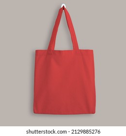 Red blank cotton eco tote bag, design mockup. Shopping bag hanging on wall - Shutterstock ID 2129885276
