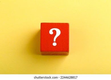 Red block with question mark isolated on yellow background with copy space.