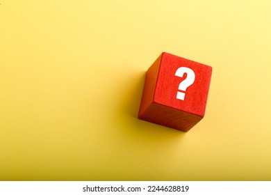 Red block with question mark isolated on yellow background with copy space.