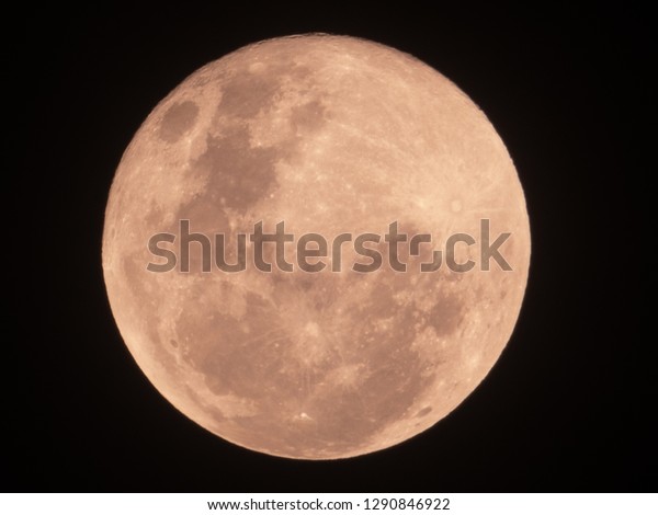 Red blood full moon on night sky. The full moon is\
lunar phase when appear fully illuminated from Earth\'s perspective.\
It occurs when Earth is located between Sun and Moon appears as a\
circular disk