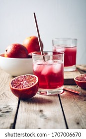 Red Blood Orange Cocktail, Citrus Drink With Ice Cubes On A Wooden Background.