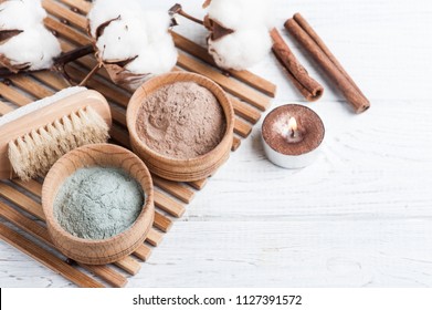 Red And Blue Cosmetic Moroccan Clay Powder, Spa Composition With Lit Candle On White Background