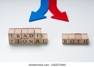 Red And Blue Directional Arrows Showing Traditional And Roth Ira Options On Wooden Blocks