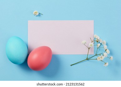 Red and Blue Easter Eggs and Card on Blue Background