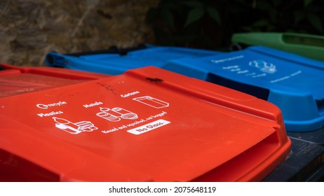 Red, Blue And Green Recycling Trash Cans In A Garden With Instructions Written On The Lid