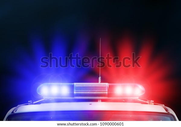 Red and blue light flasher of a police car.\
Siren on police car flashing. Red and Blue flasher on the police\
car at night. Dark\
background.