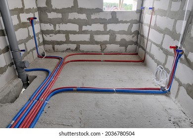 Red and blue pipes of the water supply and heating system in a country house under construction. Installation of a water supply system in a country house