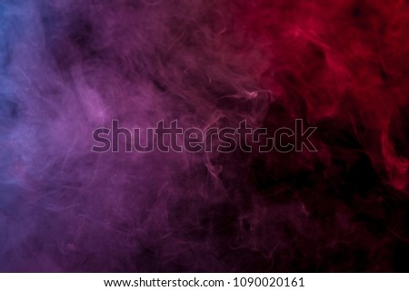 Red, blue and purple cloud of smoke of  black isolated background. Background from the smoke of vape