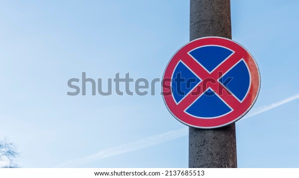 Red and\
blue traffic sign in front of beautiful blue sky says absolute no\
stopping here also on the hard shoulders. Road sign standing is\
prohibited. Road signs No stopping or No\
parking.