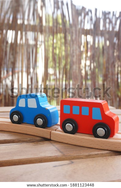 Red and blue\
wooden toy vehicles on a\
track