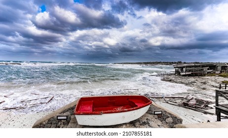 red boat on the beach due to strong waves and cloudy sky