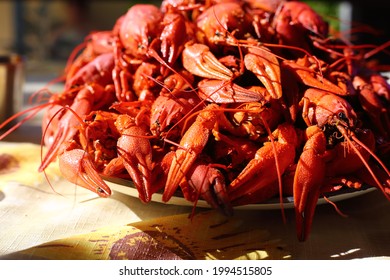 Red boiled crayfish are piled on the table in a large dish. Summer, evening, outdoor recreation.
Close up, shallow depth of field. Background, wallpaper.
