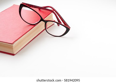Red book and glasses on a light background