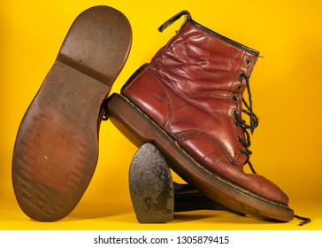 Red Boots On A Yellow Back Drop.