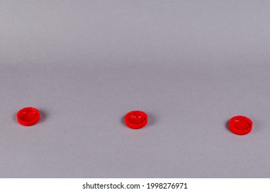 Red Bottle Stoppers Gainsboro Background. Minimalist Composition With Three Plastic Soft Drink Stoppers.