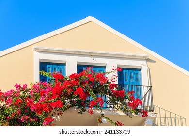 Red Bougainvillea flowers on balcony of typical Greek house in Fiskardo town, Kefalonia island, Greece - Powered by Shutterstock