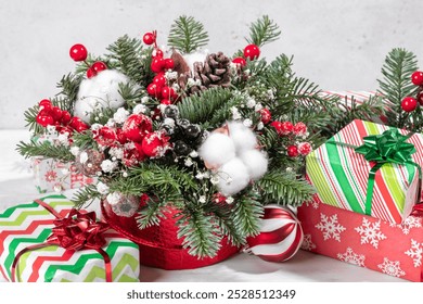 A red box with white flowers and pine cones inside. The box is placed on a white surface - Powered by Shutterstock