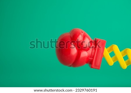 Red boxing glove fist punching toy on green background copy space. Concept of special offer boxing day sale, big knockout sale, promotion discount percent off in department store or online shopping.