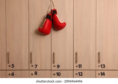Red boxing gloves hanging on locker door in changing room