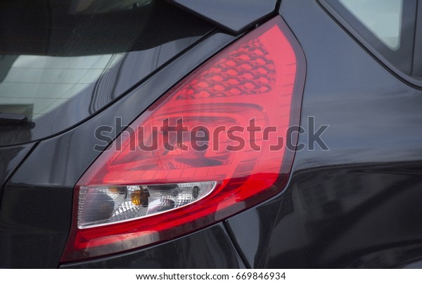 Red brake lights of a black\
car.