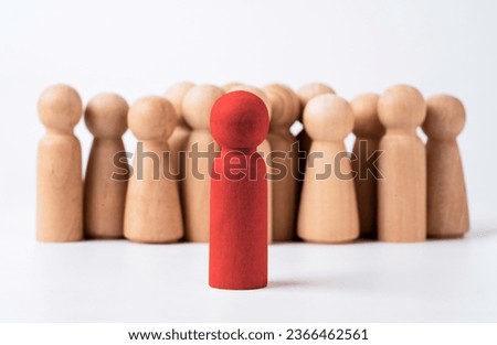 Red brave wooden figure stand in front of crowd normal figure for leadership and management concept.