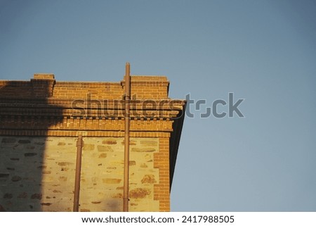 A red brick building against the background of a blue sky. Industrial building at golden hour. Golden light on a red brick building.