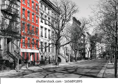 Red brick building highlighted on a block of old black and white buildings in the East Village of Manhattan, New York City NYC