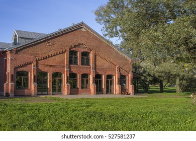 Red Brick Building with Large Windows behind Trees