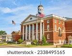 Red brick building with wind vane and American flags out front