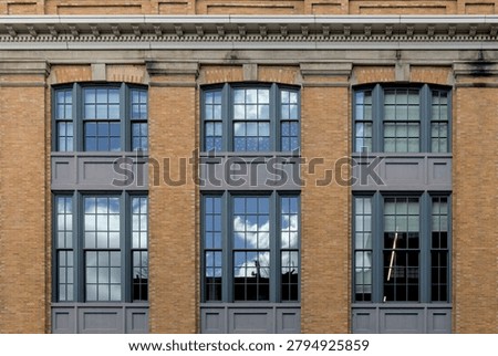 red brick building window close up view with sky clouds reflection in the glass windows (meatpacking district west side of manhattan new york city) urban historic industrial commercial residential usa