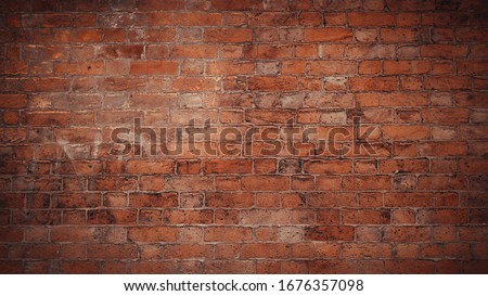 Red brick pattern. Old brick wall with cracks and scratches. Horizontal wide brickwall background. Distressed wall with broken bricks texture. Vintage house facade.