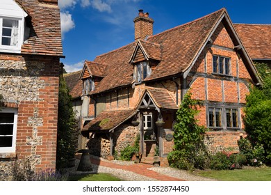 Red brick and roof tile English Tudor cottages in Turville in full sun with blue sky Turville, Buckinghamshire, England - June 22, 2019